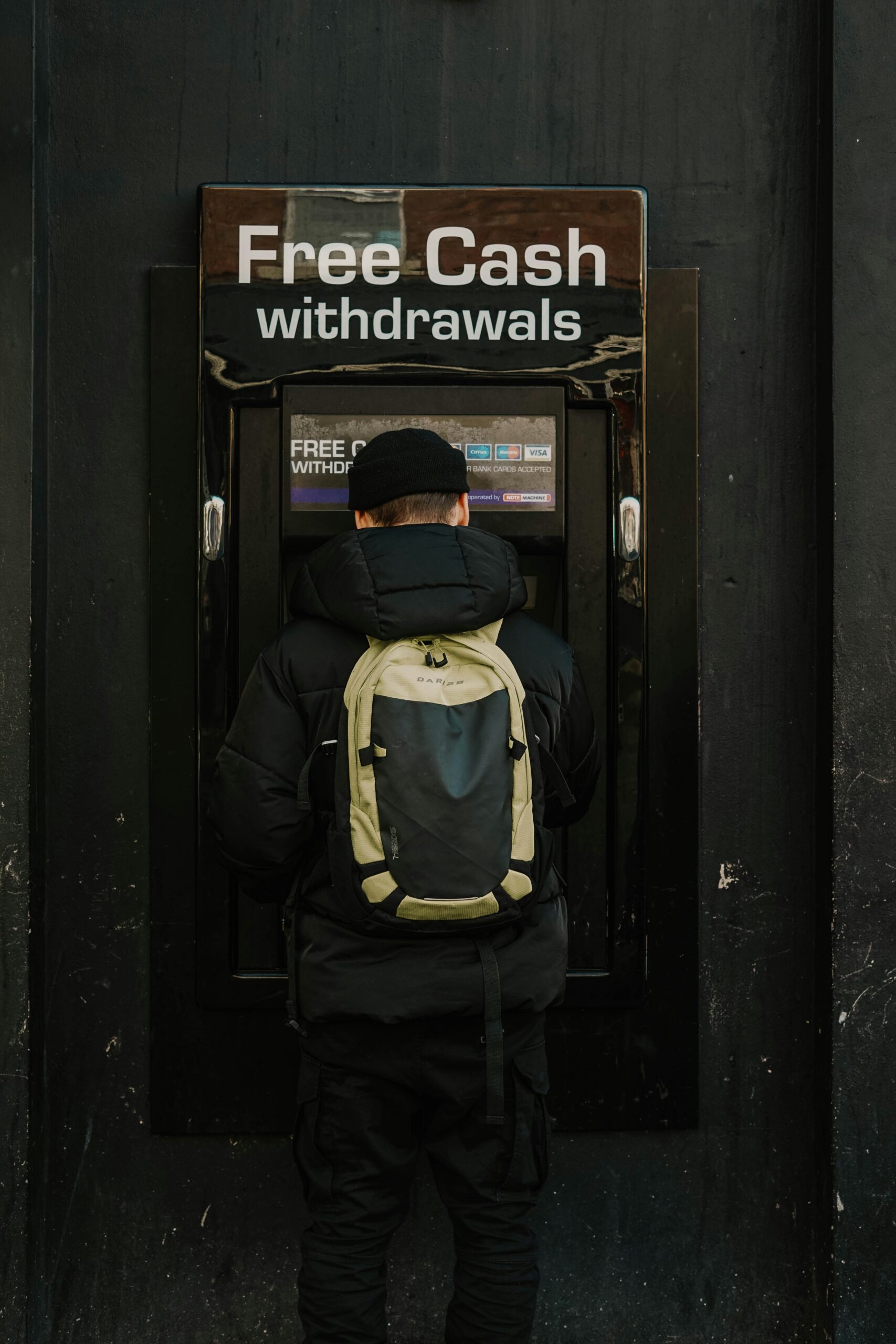 Hombre con chaqueta azul y amarilla frente a puerta de madera, simbolizando opresión financiera.