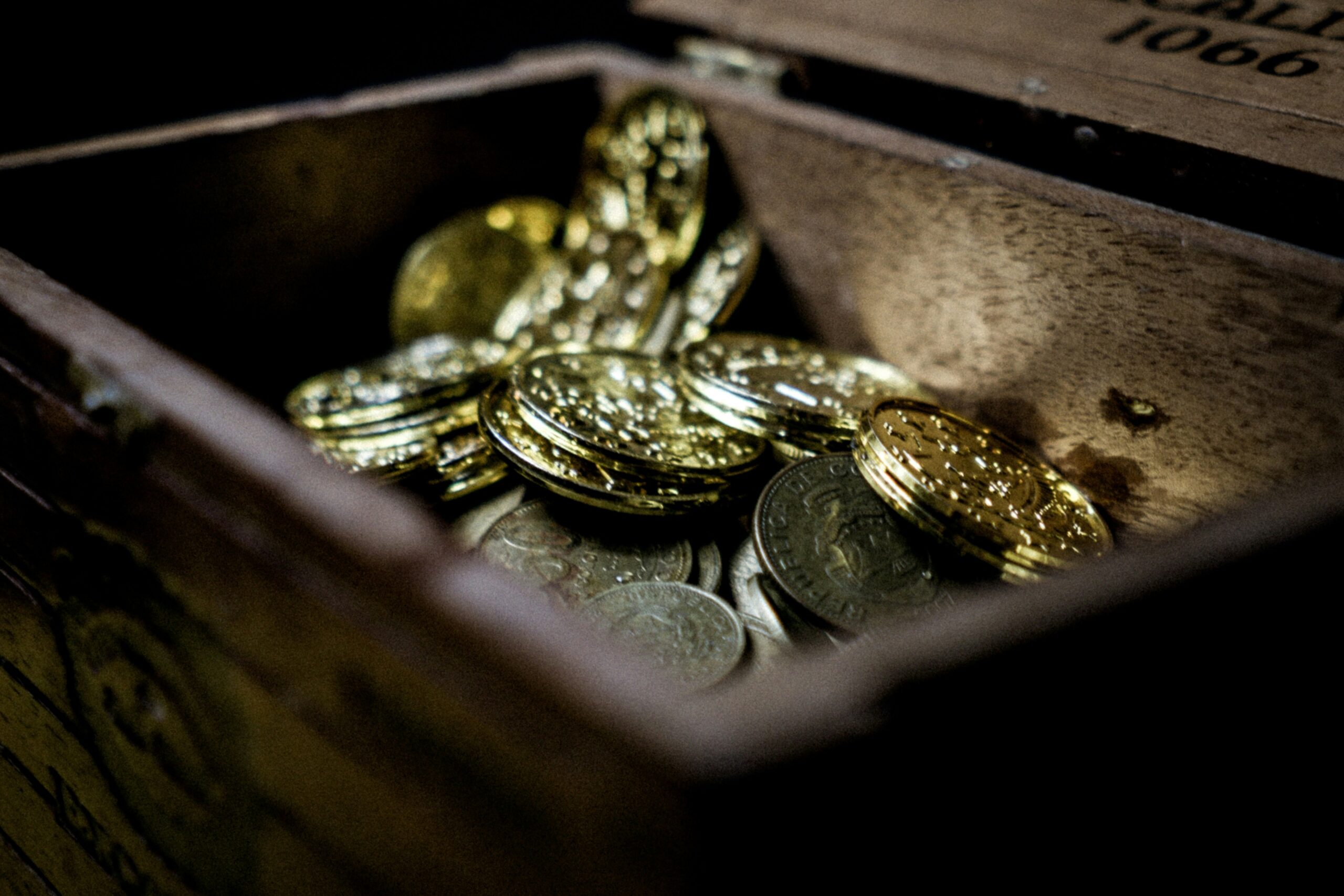 Caja de madera con monedas representando nichos rentables
