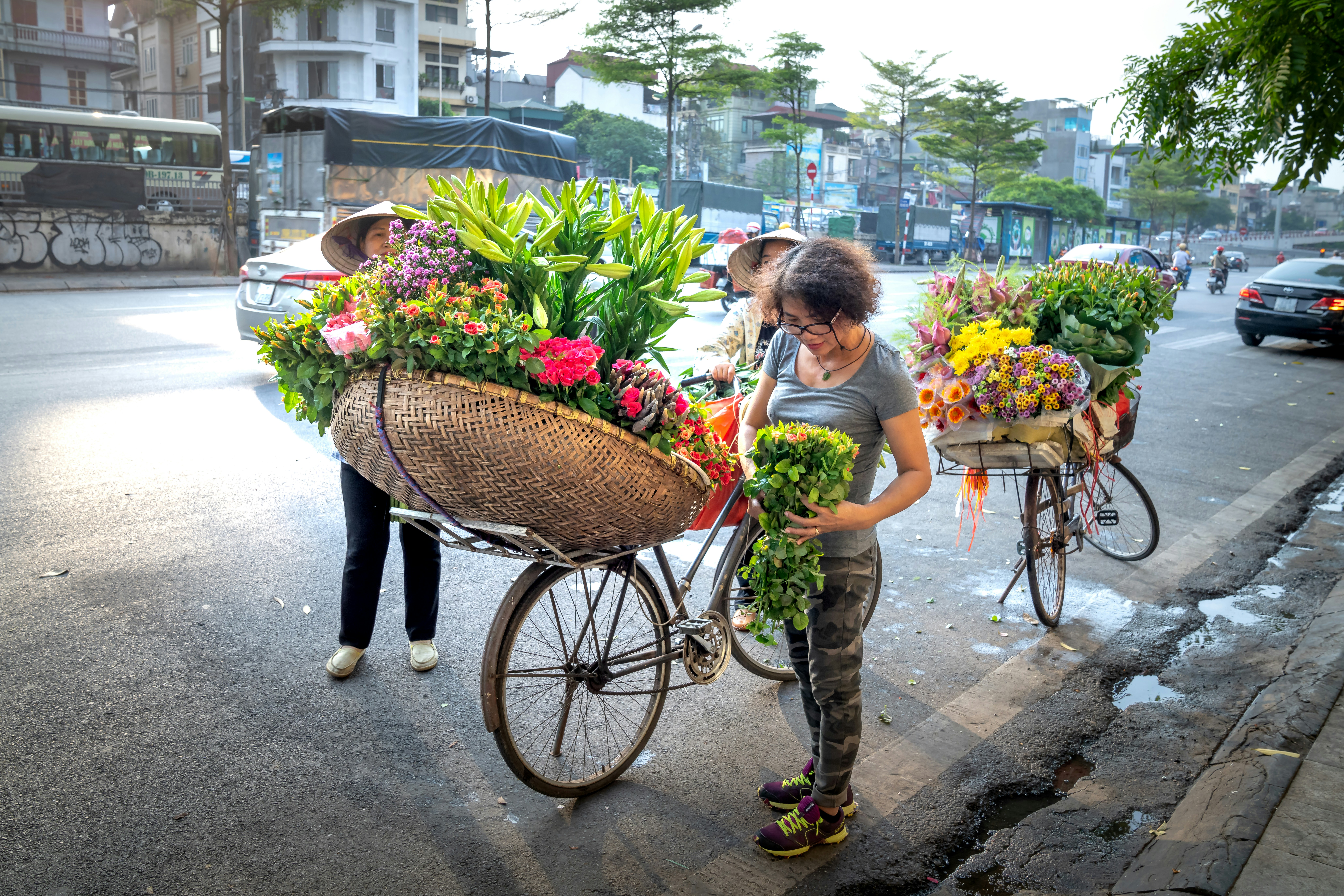 Mujer vendiendo flores en bicicleta en el libre mercado